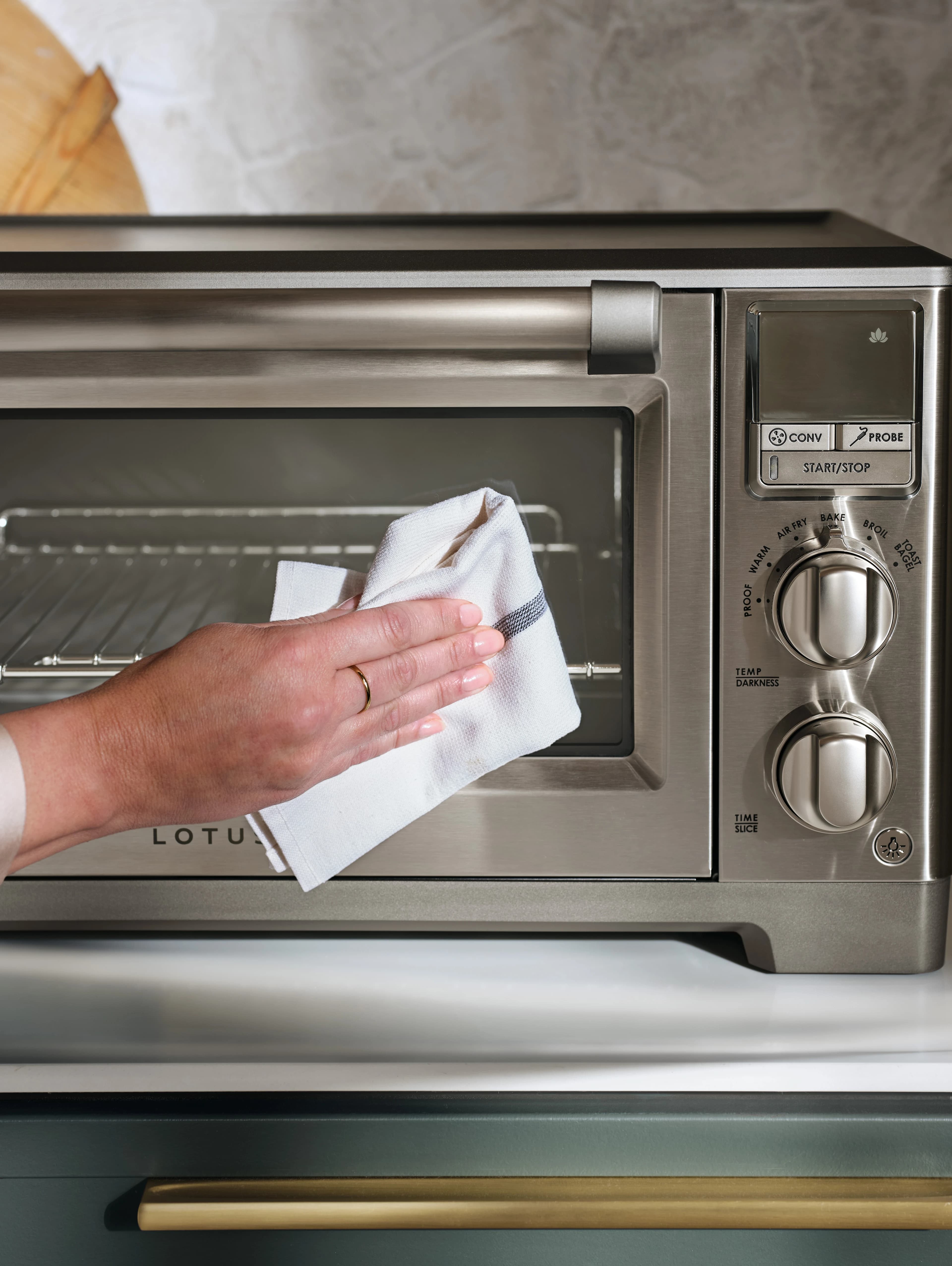 close up of a person cleaning the front of the perfectionist™ air fry and convection oven model ltsco500